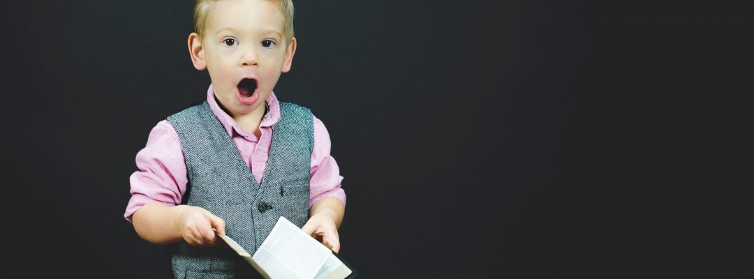 Boy holding book looking awed to represent a wonderful learning experience